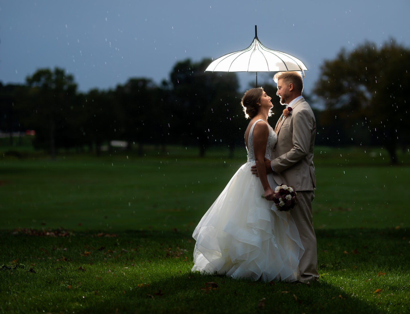 Wedding photography is a skilled profession, especially in Maryland. Photo by husband and wife team Heather & Rob Wedding Photography. Umbrella, backlit, rain, golf course.